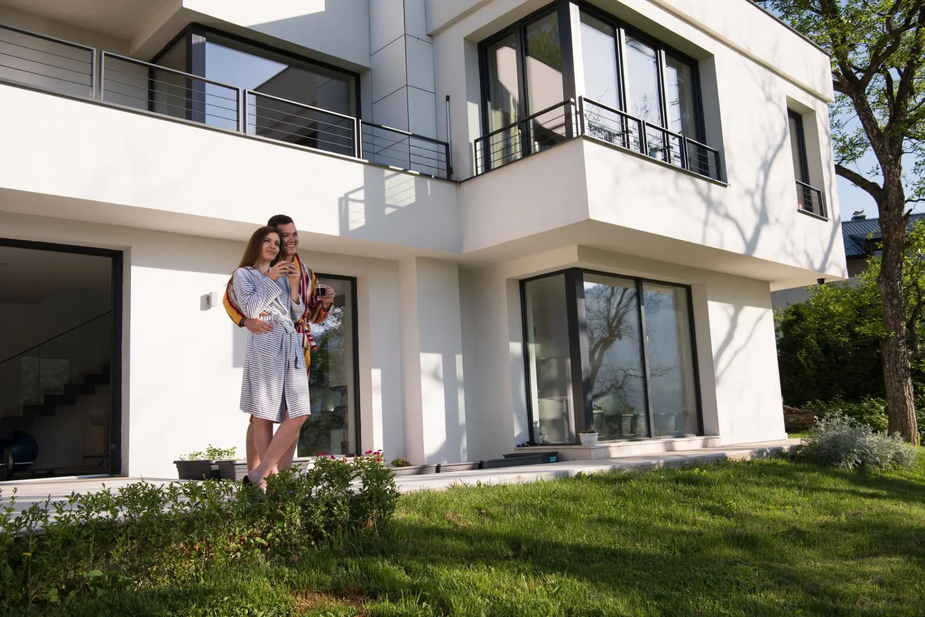 Clients heureux devant leur maison avec façade rénovée et garantie décennale à Talence